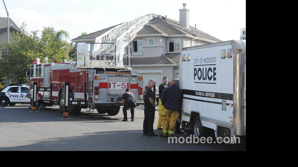 Modesto Regional fire fighters and city of Modesto police gather outside of a home on the 4,000 block of Divan Ct. in  north Modesto where two people fell victim to a fire confined to the top floor of the home early Thursday morning (08-08-13).