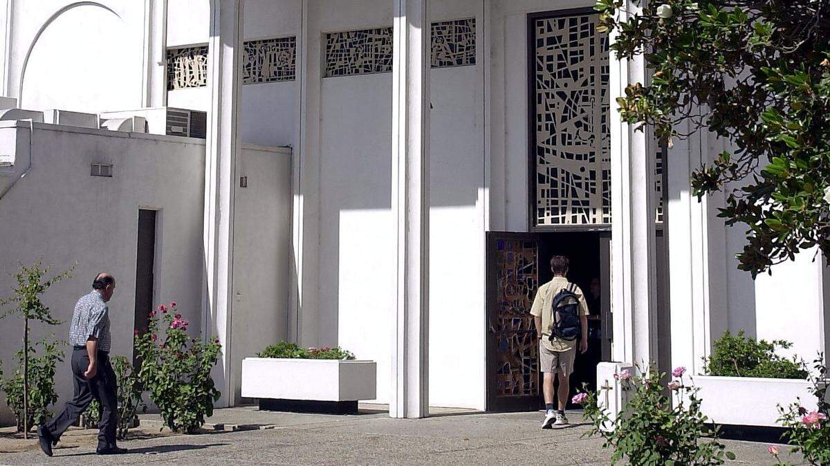 Church members make their way into Sacred Heart Church in Turlock on Sunday, July 21, 2002. This was the first Sunday service held since the Rev. Oscar Pelaez admitted his guilt and was sentenced to six years in prison for molesting a 13-year-old boy from Sacred Heart Church.