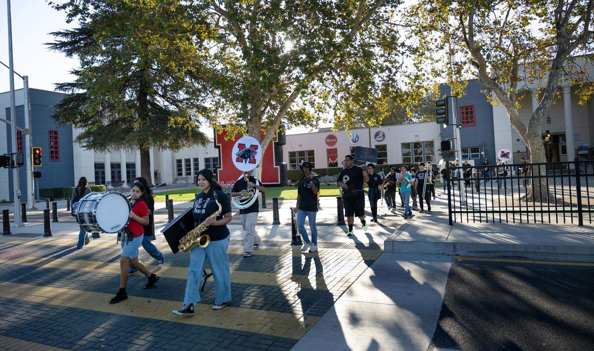 Members of the school band cross Paradise Road outside Modesto High School in Modesto, Calif., Tuesday Oct. 8, 2024. 