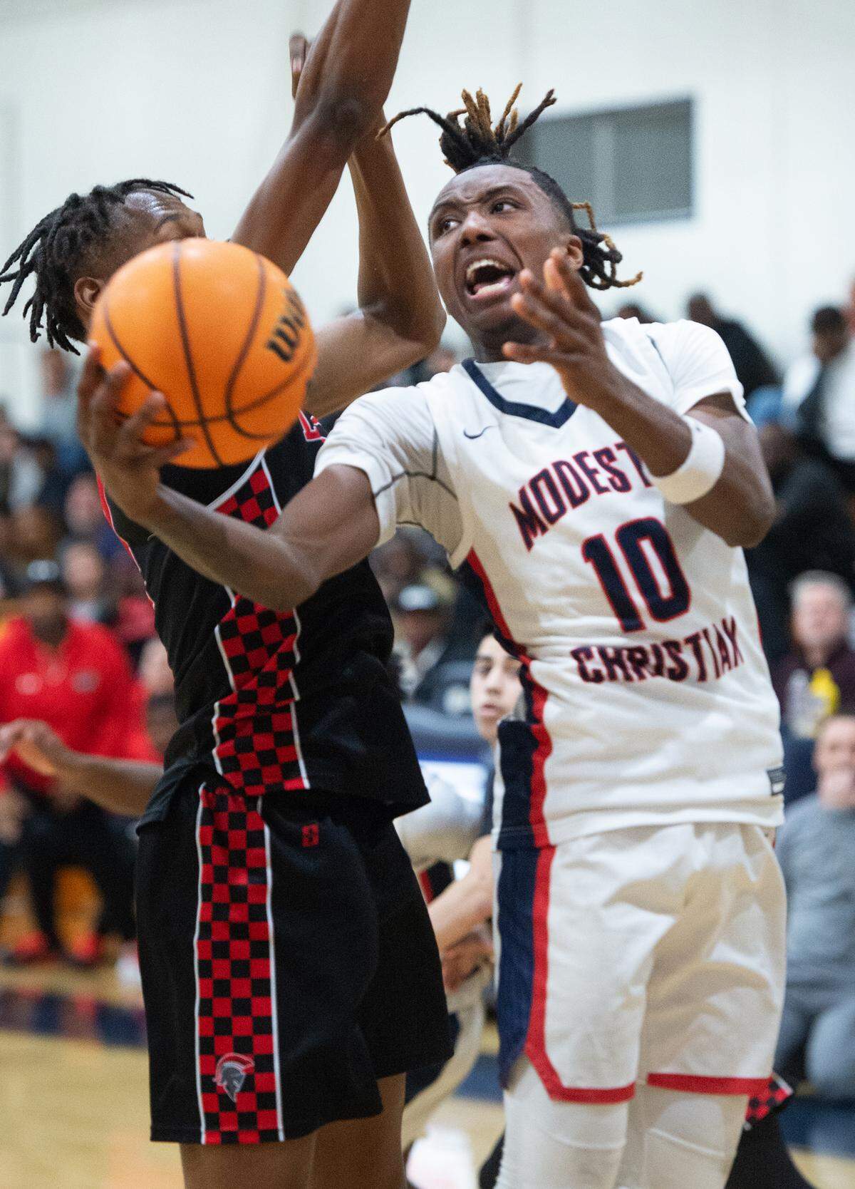 Modesto Christian’s BJ Davis scores and draws a foul from Lincoln’s Anthony Moore during a Sac-Joaquin Section Division I playoff game at Modesto Christian High School in Salida, Calif., Friday, Feb. 17, 2023.