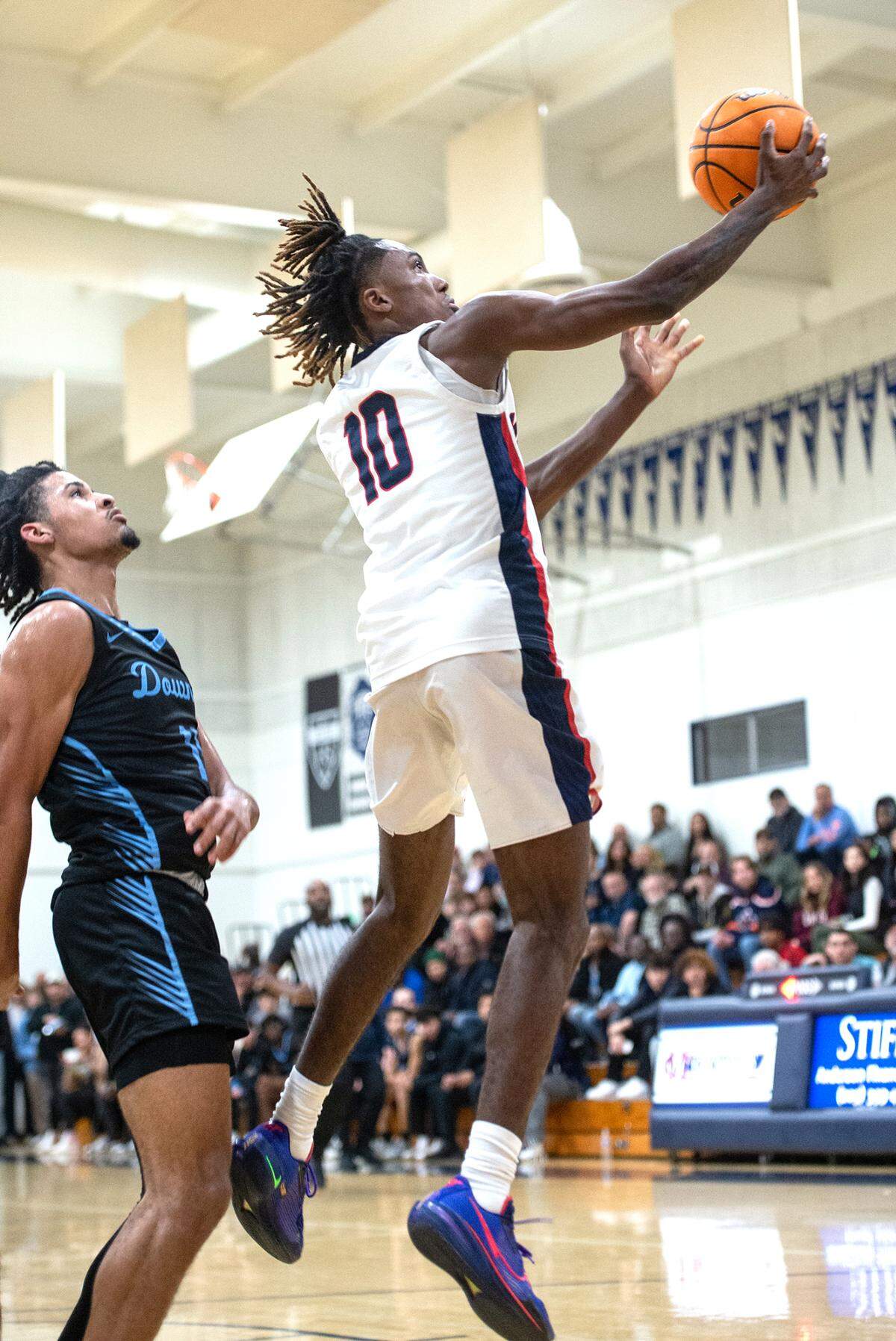 Modesto Christian’s BJ Davis attempts a layup past Downey’s Lloyd French during the first round game in the Modesto Christian Holiday Hoop Classic in Salida, Calif., Tuesday, Dec. 27, 2022. MC won the game 44-37.