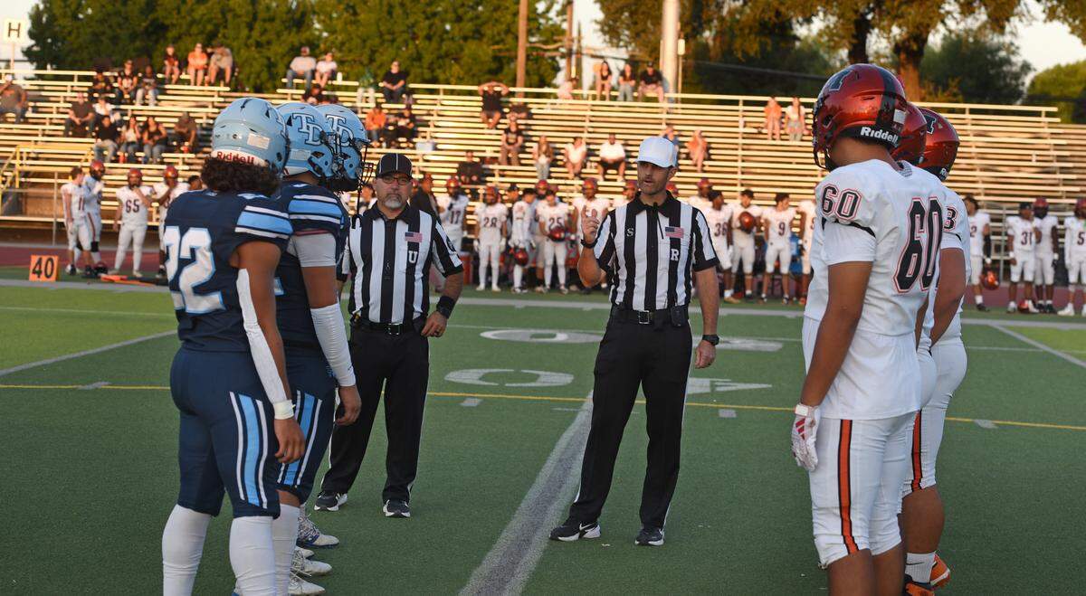 Merced and Downey captains at the coin toss before the game at Downey High School in Modesto, Friday, Sept. 5, 2025.