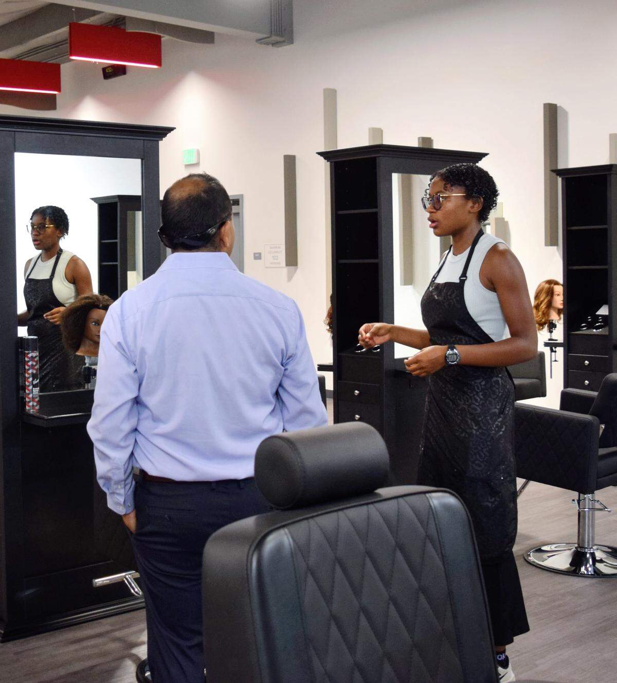 Patterson High Senior Ermandrea Osborne talks with community members at the opening of the school’s new Barbering and Cosmetology Building on Aug. 9, 2025.