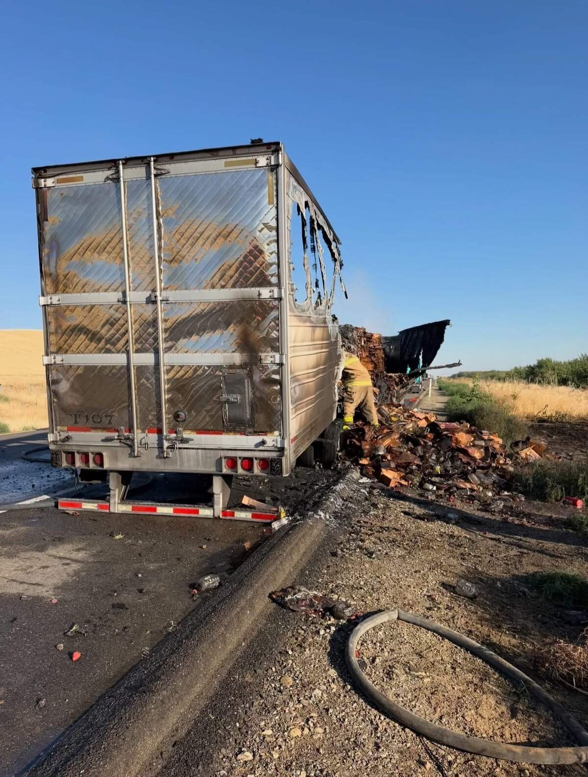 A burned trailer carrying approximately 22,000 pounds of strawberries sits along the shoulder of northbound Interstate 5 north of Howard Road near Westley after catching fire Thursday morning. The blaze closed the right lane for several hours while crews extinguished the fire and removed the damaged trailer.