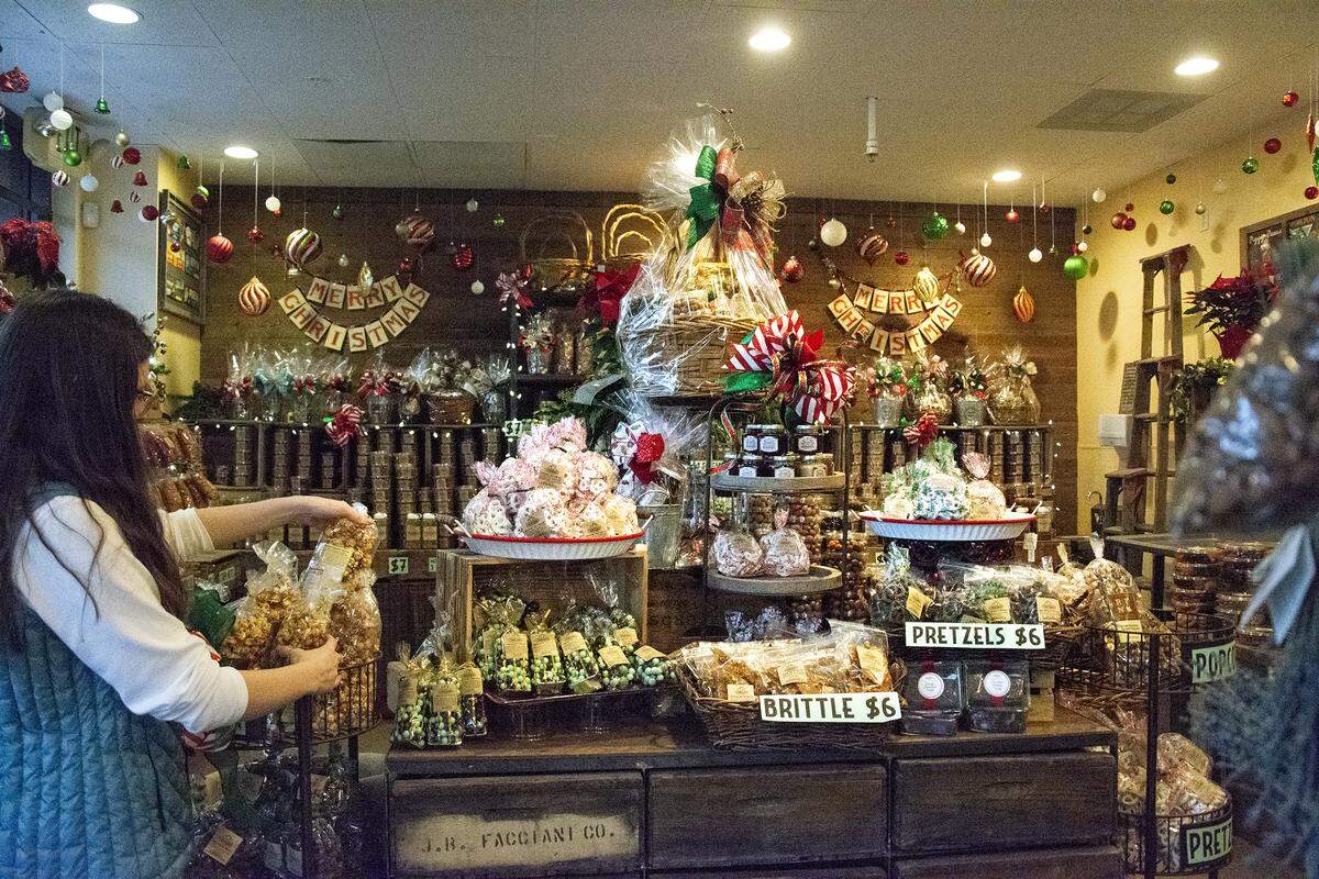 Sierra Gish fixes a display inside the Rodin Ranch Farmers’ Market in downtown Modesto, Calif.