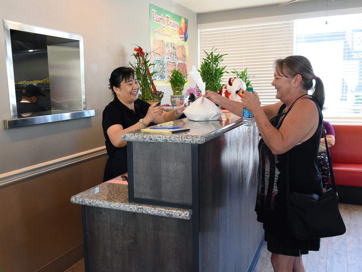Customer Vicki Cook picks up her order from Sally Guan Wednesday afternoon July 10, 2019 at Lee’s Chinese Kitchen in Modesto, Calif.