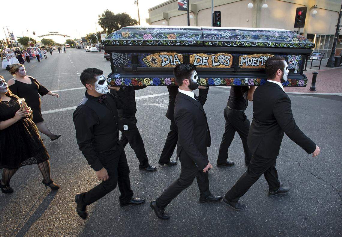Men carry a ceremonial casket during a past year’s Dia de los Muertos procession in downtown Modesto.