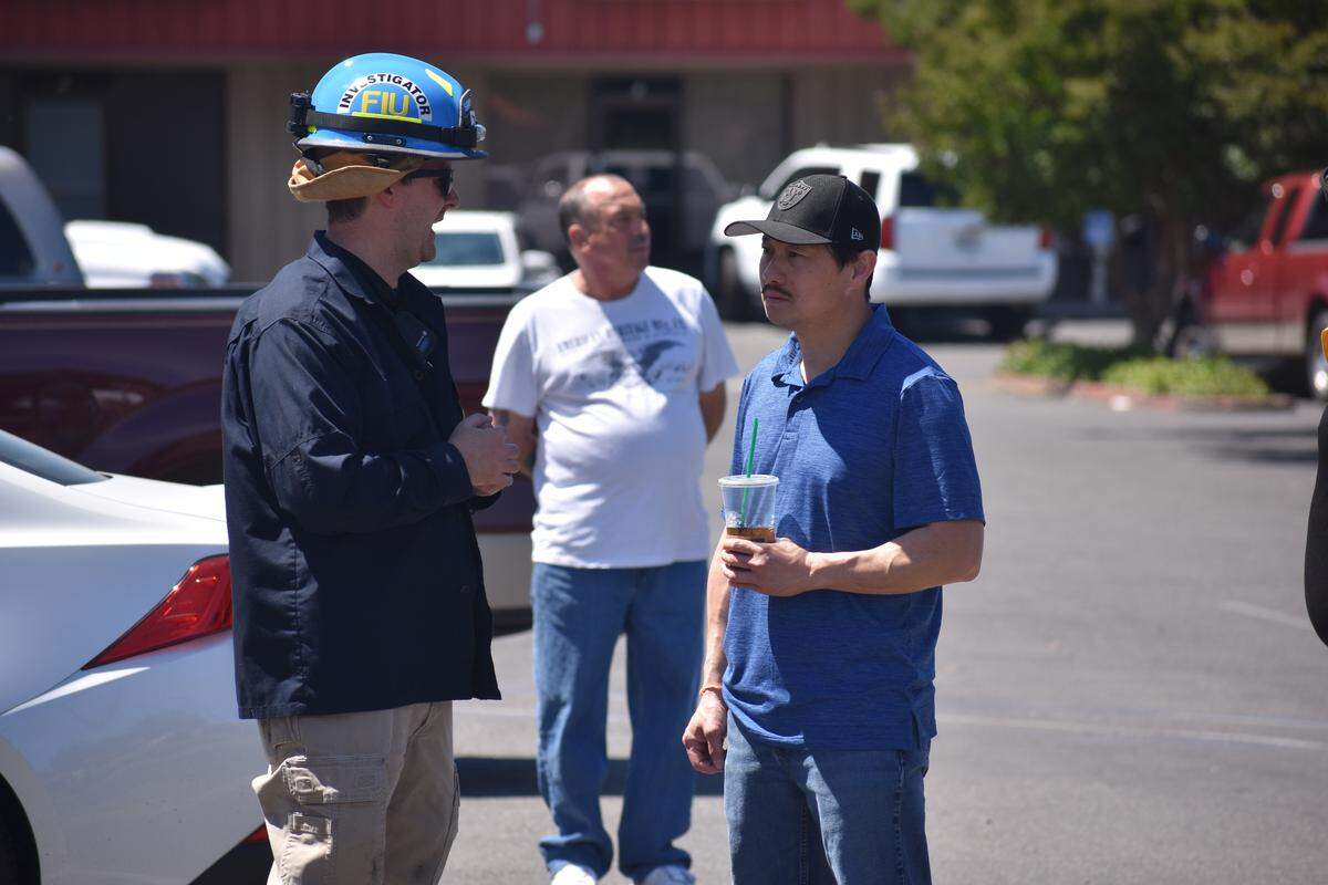 Trong Vuong speaks to a fire investigator on Saturday June 8, 2019. A fire destroyed his Asian Market, a business his family has owned and operated for more than 35 years at the shopping center in the 1100 block of Carver Road in Modesto, California.