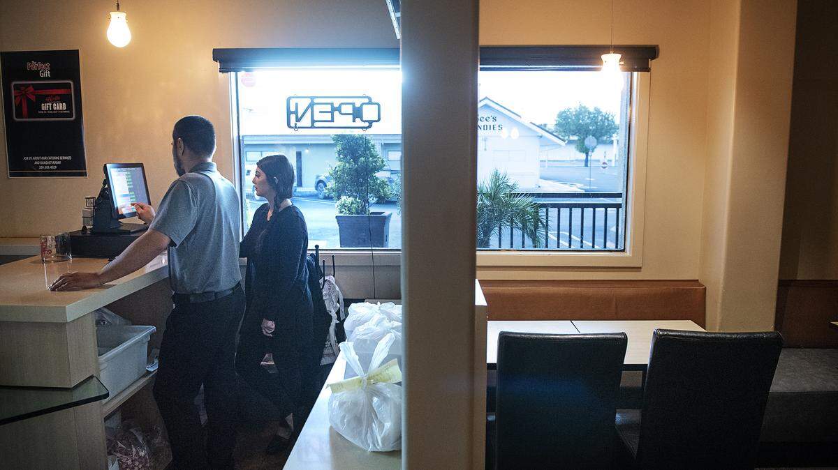 Daniel Zepeda and Diana Valadez enter a take-out order at La Parilla in Modesto, Calif., on Saturday, March 21, 2020.