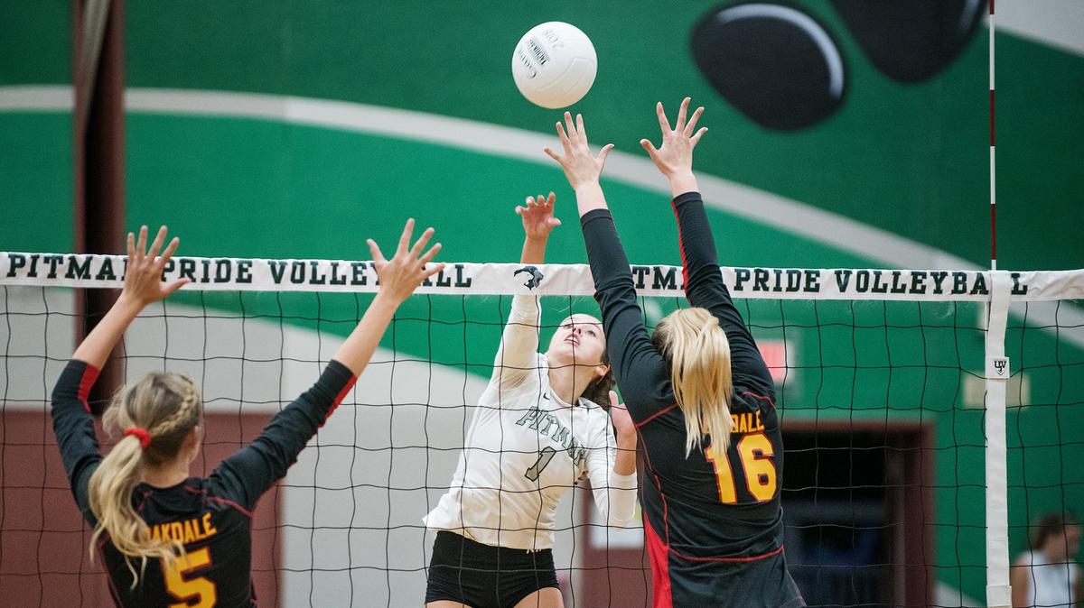 Pitman’s Cierra Verdone spikes the ball past Oakdale’s Grace Verdegaal (5) and Brittany Gibson (16) during Thursday’s match at Pitman High School n Turlock, Calif., August 30, 2018.