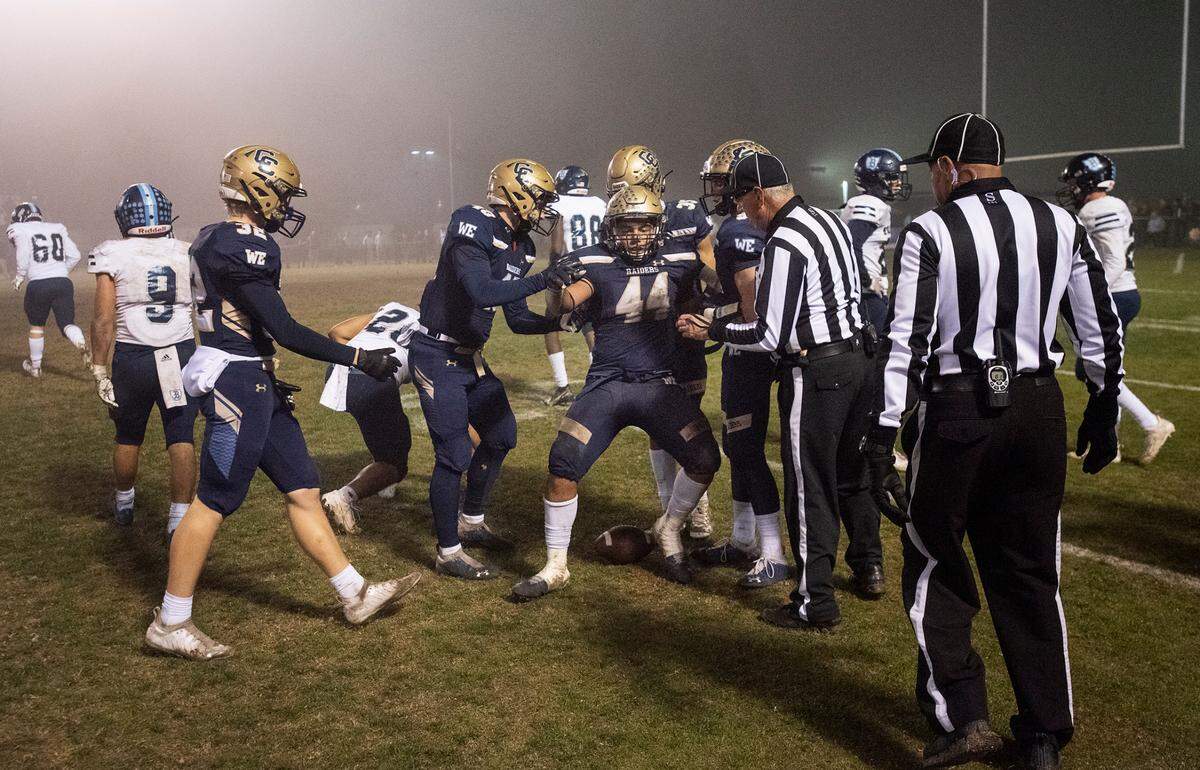 Central Catholic’s Aiden Taylor is helped up by his teammates during the CIF Division II Northern California Regional Championship game with Bullard (Fresno) at Central Catholic High School in Modesto, Calif., Dec. 3, 2021. Central Catholic won the game 44-41.