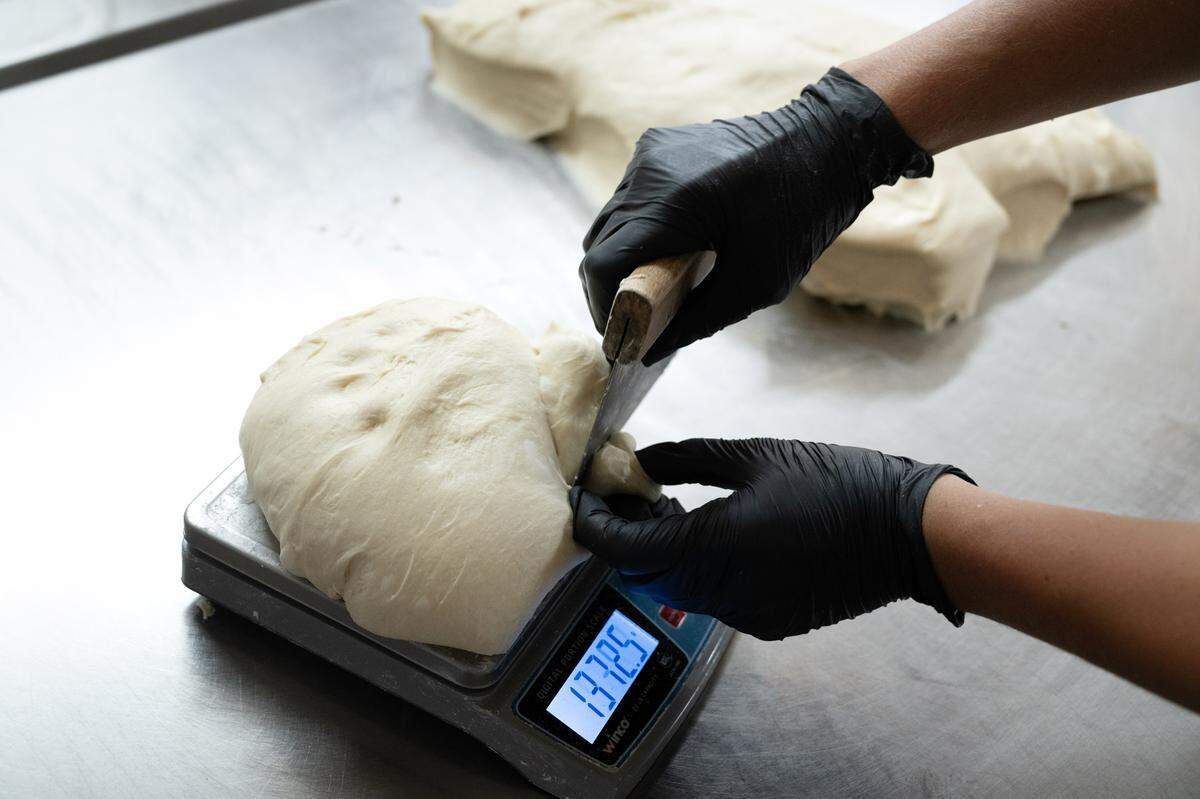 Emily Melgard measures out dough for loaf bread at MatKat Sourdough bakery in Oakdale, Calif., Wednesday, July 24, 2024.