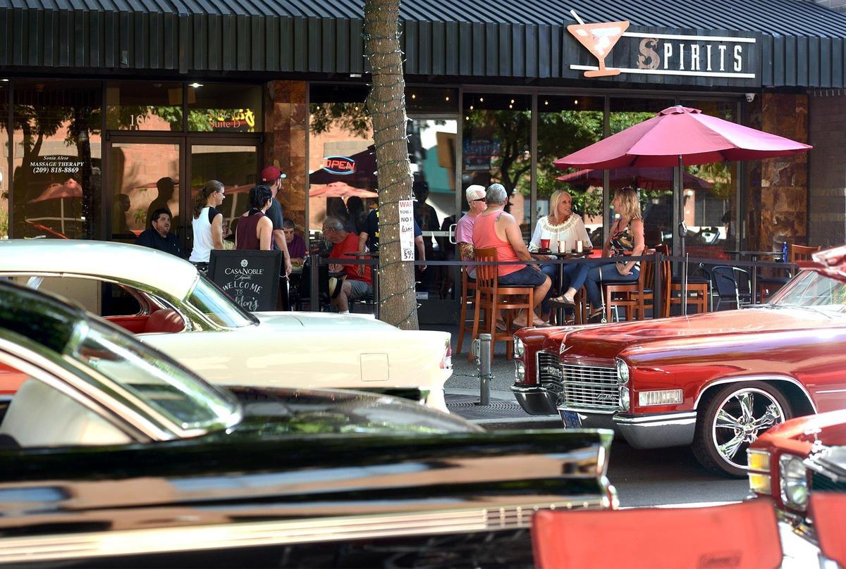 People enjoy themselves amongst classic cars on 10th street near J street before the start of the Legends of the Cruise Walk of Fame Wednesday May 5, 2019 in downtown Modesto, Calif.