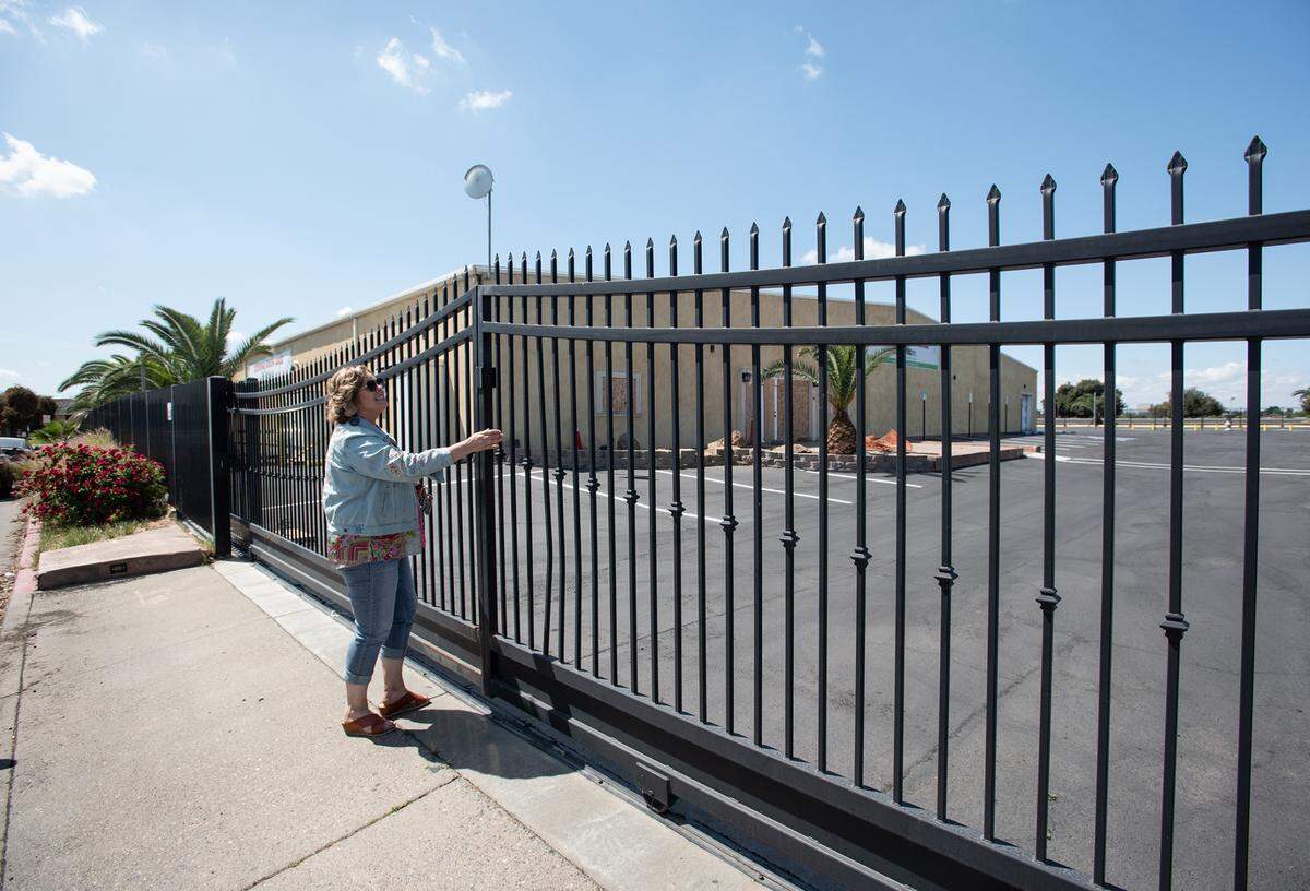 Habitat Stanislaus CEO Anita Hellam opens the gate at the future site of the new Habitat for Humanity ReStore on Tenaya Drive in Modesto, Calif., on Friday, April 15, 2022.