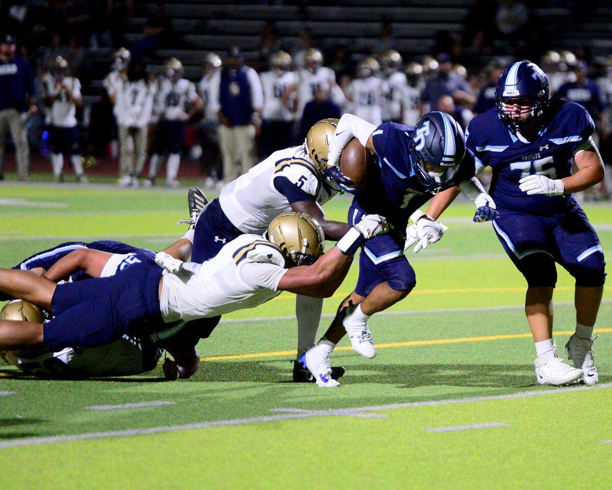 Downey running back Julius Padron (1) fights off two Elk Grove defenders during a game between Downey High School and Elk Grove High School at Downey High School in Modesto, Calif. on August 30, 2024.