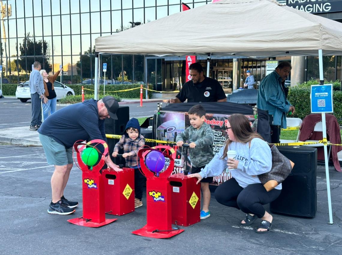 Children participate in a balloon game as they wait for rappellers to scale the building funding the Over the Edge fundraising event on Saturday, Oct. 12.