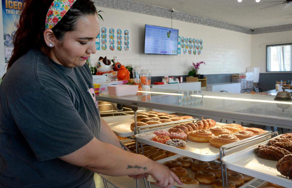 Sovanna’s Donuts employee Sarah Zeledon picks out donuts in the shop May 19, 2023.