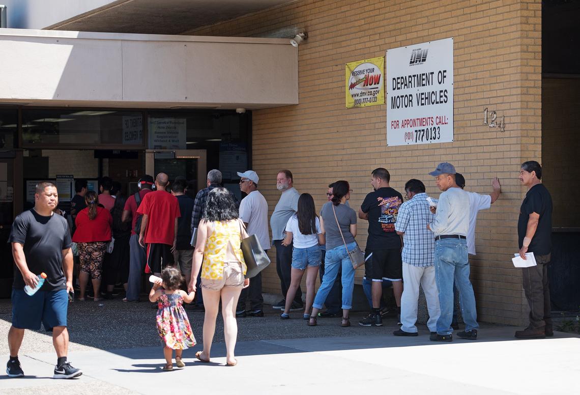 People wait in line outside the California Department of Motor Vehicles in Modesto, Calif., Friday, June 22, 2018.