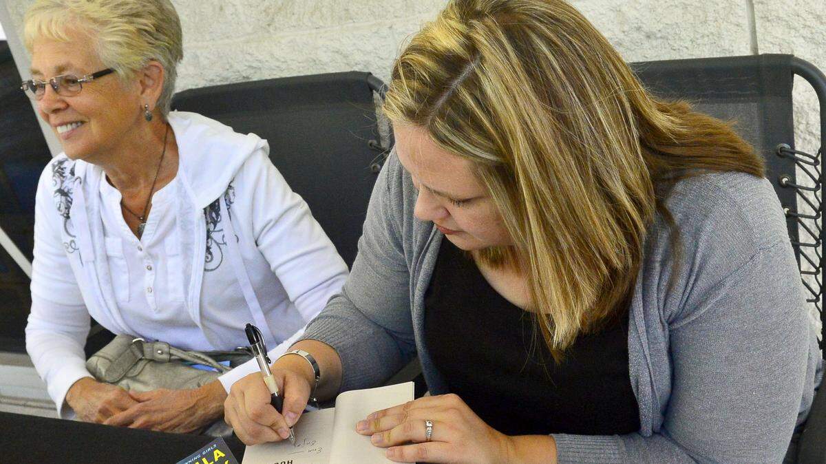 Local author Paula DeBoard signs a copy of her book at the 2016 Local Authors Fair at the Stanislaus County Library in Modesto.