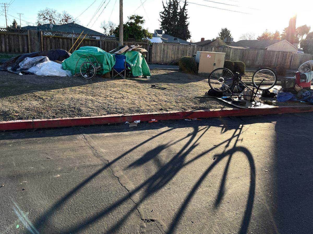 Personas sin hogar almacenan sus pertenencias detrás de un centro comercial en Hatch Road en Ceres, California, el viernes 22 de diciembre de 2023.