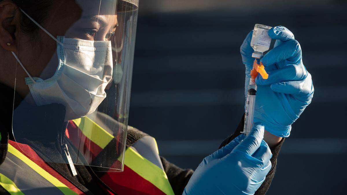 Nurse Zynda Bince prepares a flu shot as the Stanislaus County Department of Public Health conducts a drive-thru mass vaccination clinic for the flu vaccine at Johansen High School in Modesto, Calif., on Friday, Dec. 4, 2020.