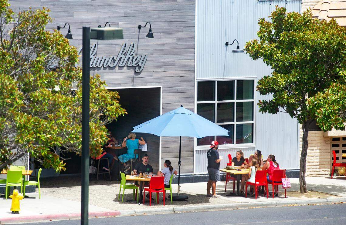 People dine outside on the sidewalk at Churchkey restaurant in Modesto, Calif., on Friday, July 10, 2020.