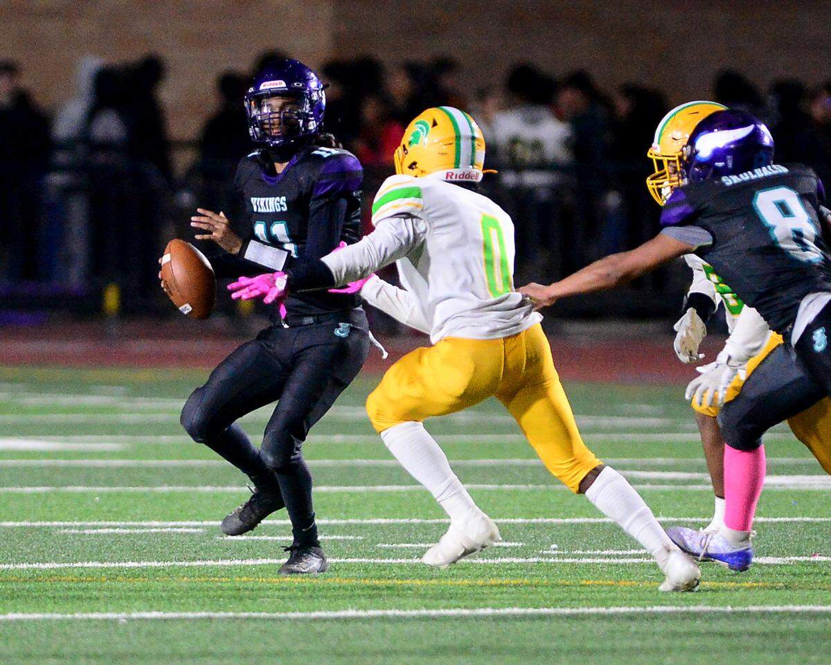 Johansen quarterback Anthony Torres (11) scrambles away from pressure during a game between Johansen and Davis at Johansen High School in Modesto California on November 1, 2024.