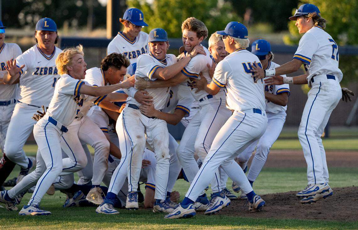 Lincoln players celebrate their Sac-Joaquin Section D-V championship title over Hughson at Islander’s Field in Lathrop, Wednesday.