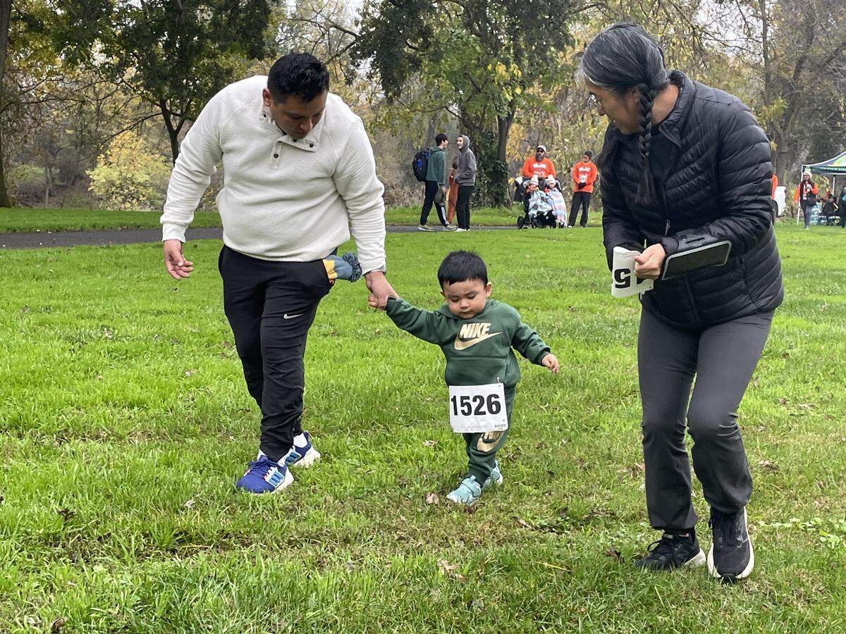 Jacob Alania, 1, was new to walking when he was entered in the Turkey Trot on Nov. 27, 2025, in Modesto, Calif. Joining him in Tuolumne River Regional Park are father Anthony Alania and aunt Carmen Alania.