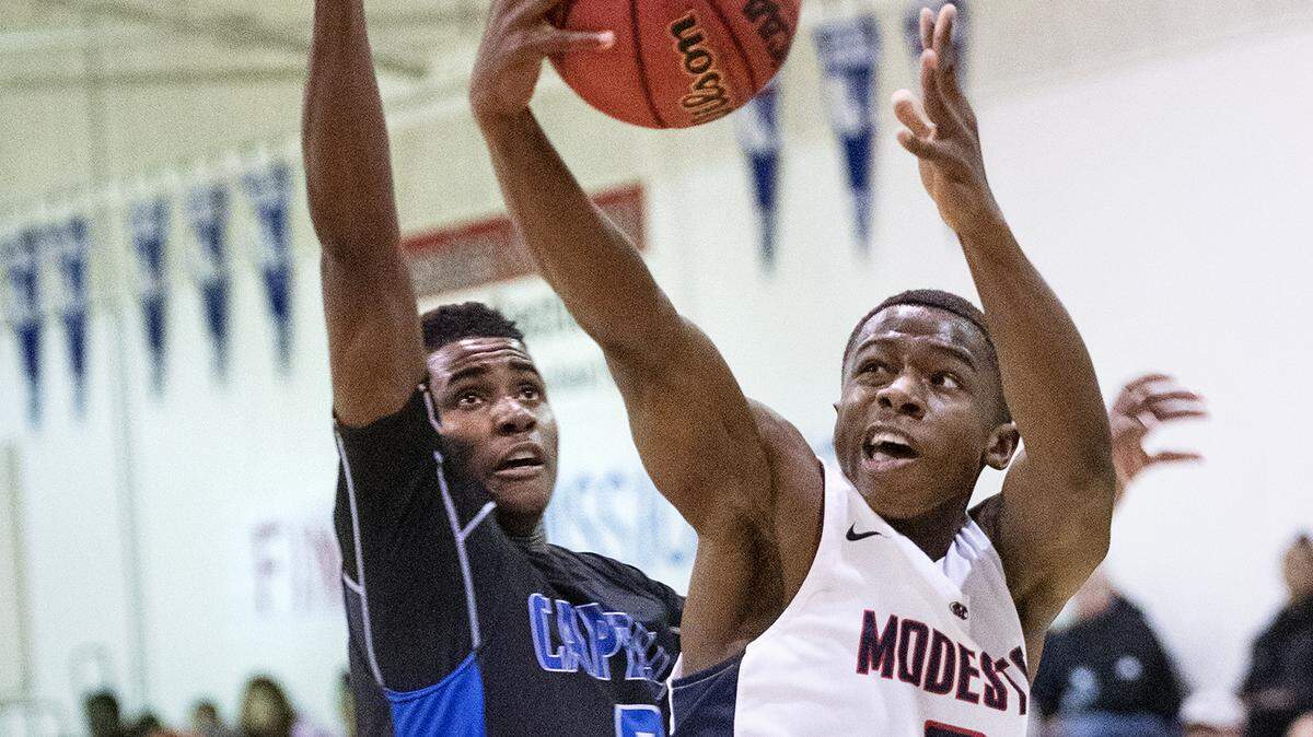 Modesto Christian’s Michael Pearson scores past Capital Christian’s Evan Johnson during the CIF Sac-Joaquin Section Division I playoff game with in Salida, Calif., Friday, Feb. 15, 2019. Modesto Christian won the game 81-52.