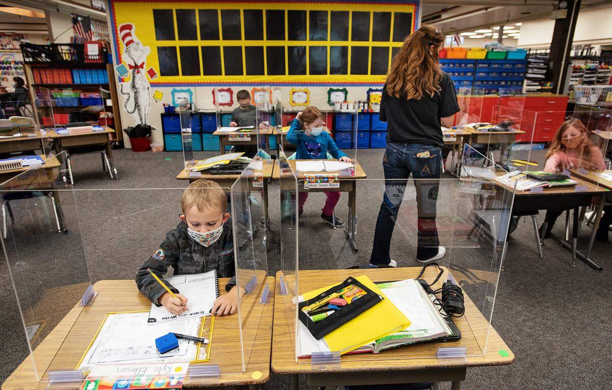 First-grade student Kyle Ellman, left, works in socially distanced seating as teacher Katie Martin conducts class at Sonoma Elementary School in Modesto, Calif., on Thursday, Nov. 12, 2020.