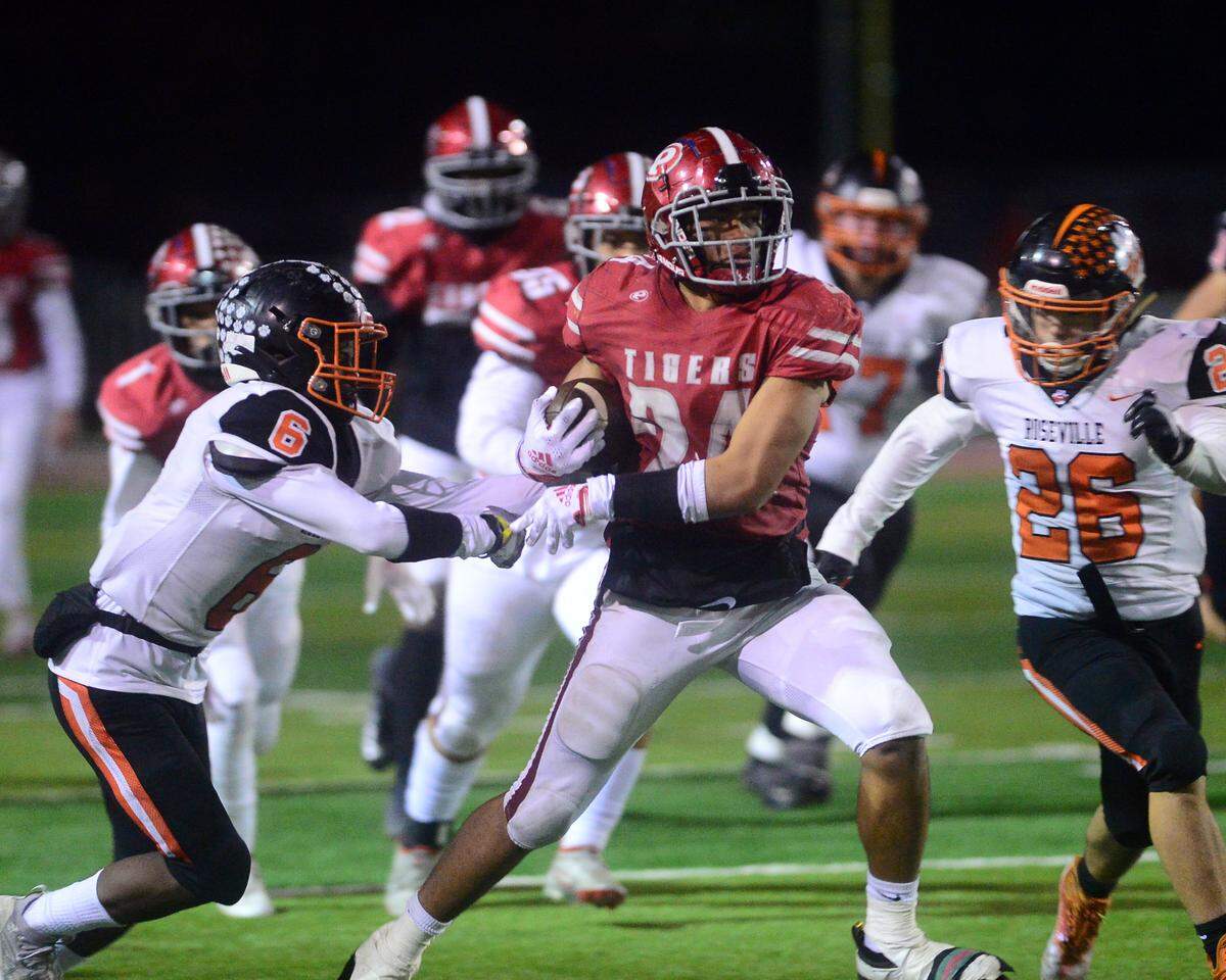 Patterson running back Lolo Mataele fights off multiple defenders during a CIF Division III Sac-Joaquin Section football playoff game against Roseville at Patterson High School in Patterson, California, on Nov. 11, 2022. Patterson won 56-34.