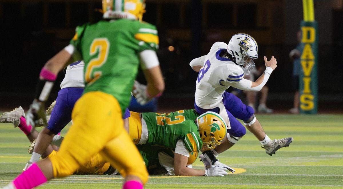 Davis defense pressures Livingston quarterback Armani Miranda in the Western Athletic Conference game at Downey High School in Modesto, Calif., Thursday, Oct. 3, 2024.