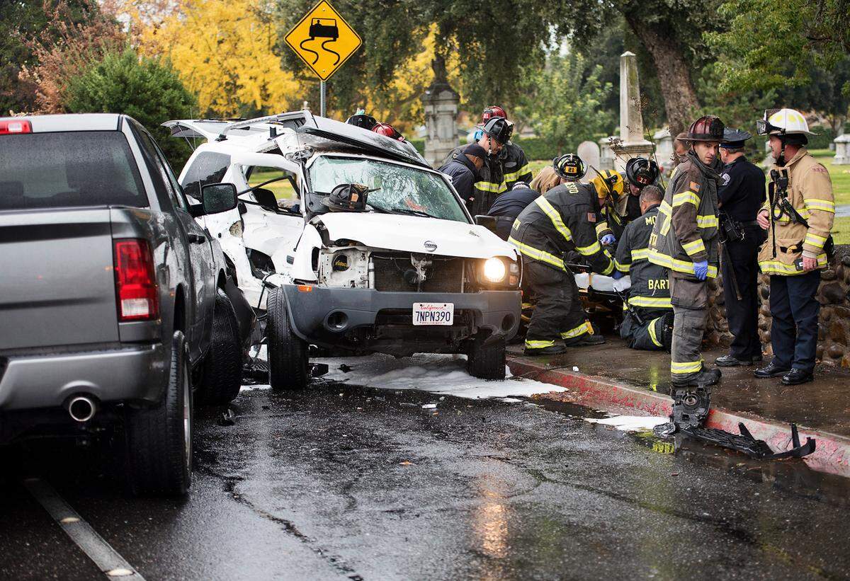 Firefighters tend to a juvenile boy after after a crash on Scenic Drive in Modesto Calif., on Saturday, Dec. 10, 2016. The boy, a woman and infant, all in the white Nissan, were transported to the hospital, the driver of the Dodge truck was not injured.