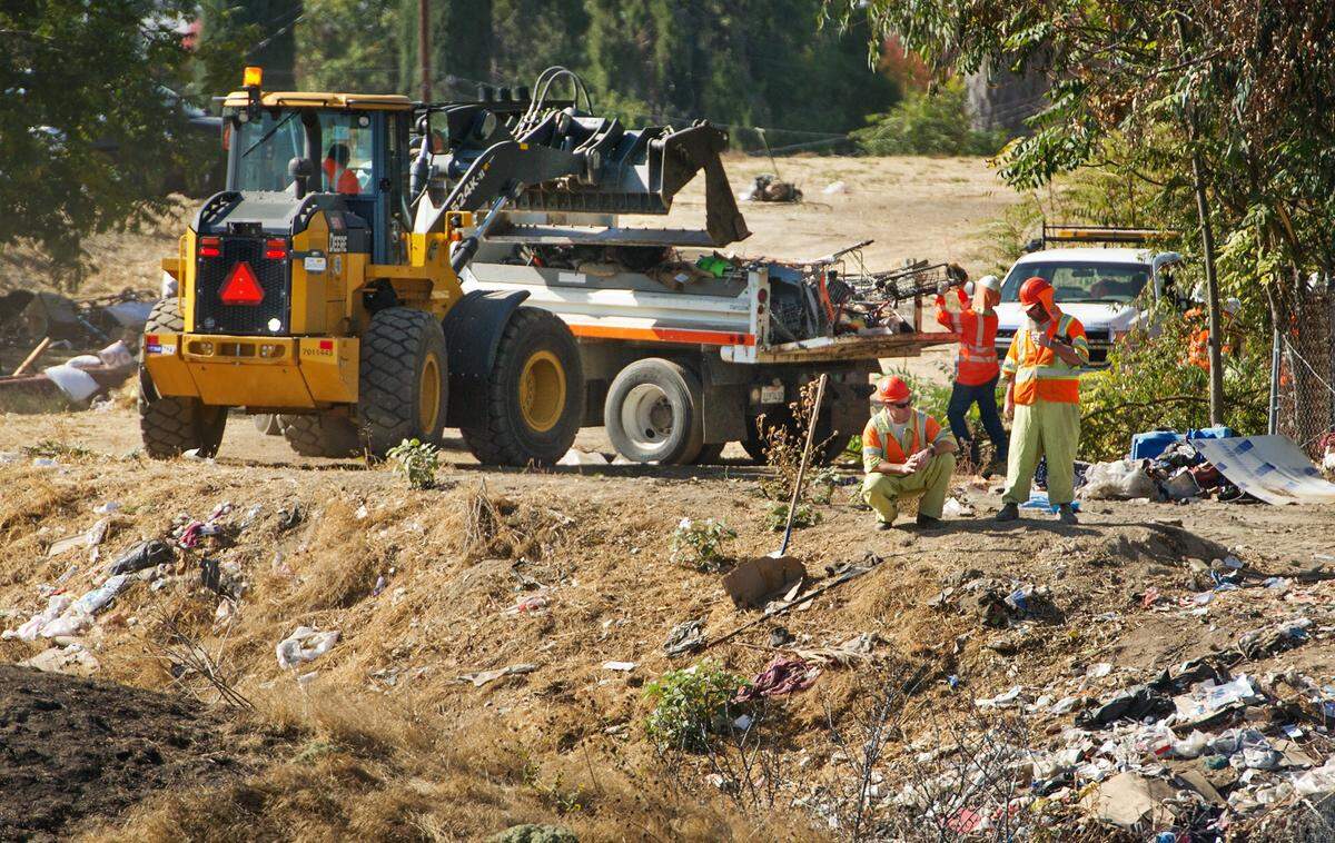 CalTrans crews clean up a homeless encampment along State Highway 99 in Modesto, Calif., Thursday, Nov. 8, 2018.