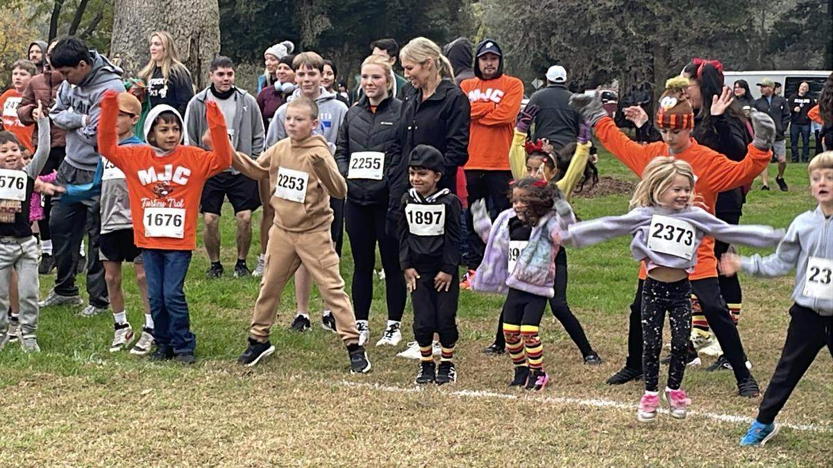 Children do jumping jacks to warm up for the Turkey Trot in Tuolumne River Regional Park on Nov. 27, 2025. It raises money for the track and cross country teams at Modesto Junior College.