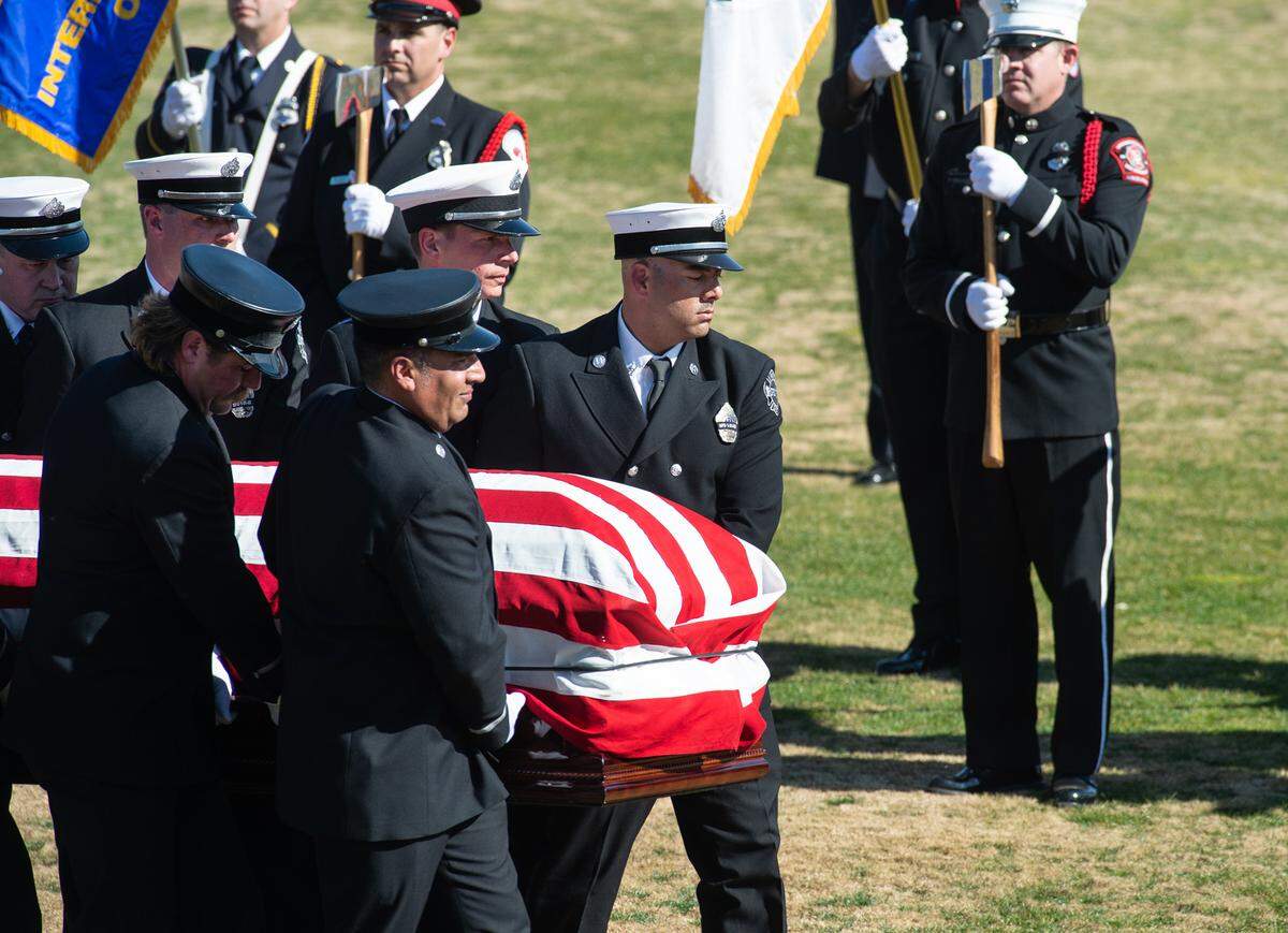 Stockton firefighters carry the body of fallen Capt. Vidal “Max” Fortuna to start the final procession during a memorial service at the Banner Island Ballpark in Stockton, Calif., on Tuesday, Feb. 8, 2022.
