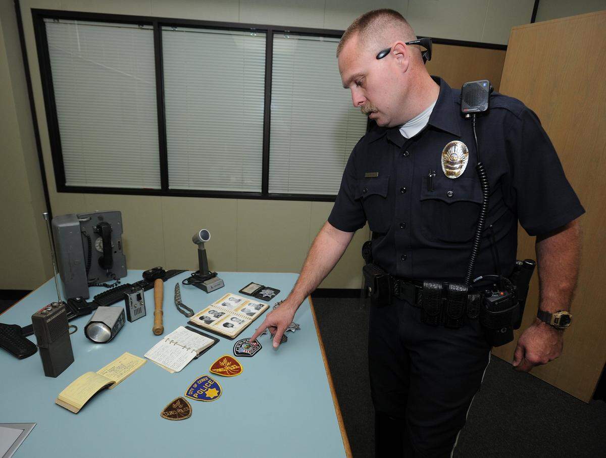 A 17-year-veteran of the Ceres police department, Officer Jason Coley, 41, stands by a table where he laid out Ceres P.D. memorabilia spanning from 1918 to 2015, on Thursday (3-12-15) in Ceres. Coley points to the new badge that the department will be soon placing on uniforms.