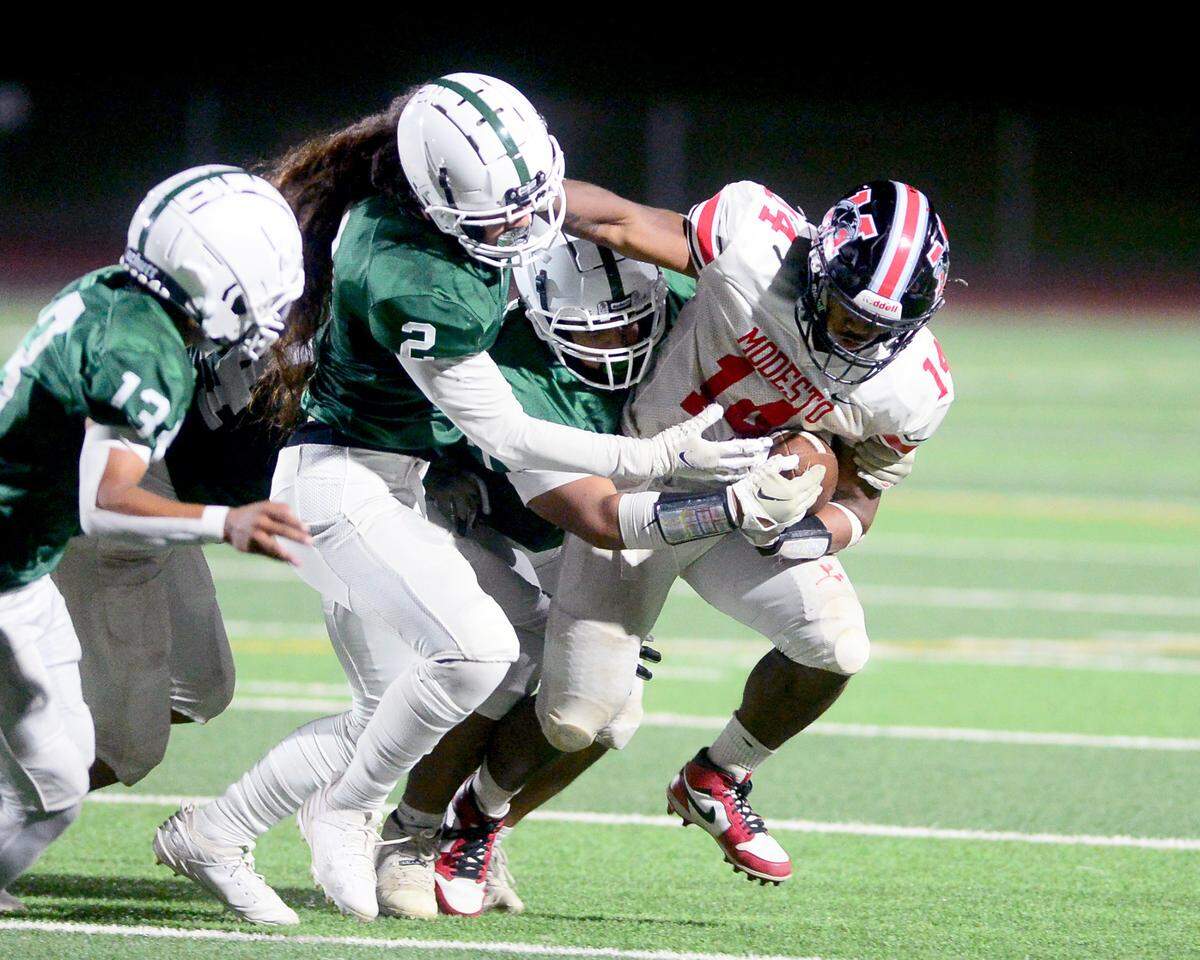 Modesto High running back Vanntheesouk ‘Lucky’ Dam (14) tries to break free from multiple Central Valley defenders during a game between Modesto High School and Central Valley High School at Gregori High School in Modesto, Calif., on Sept. 13, 2024.