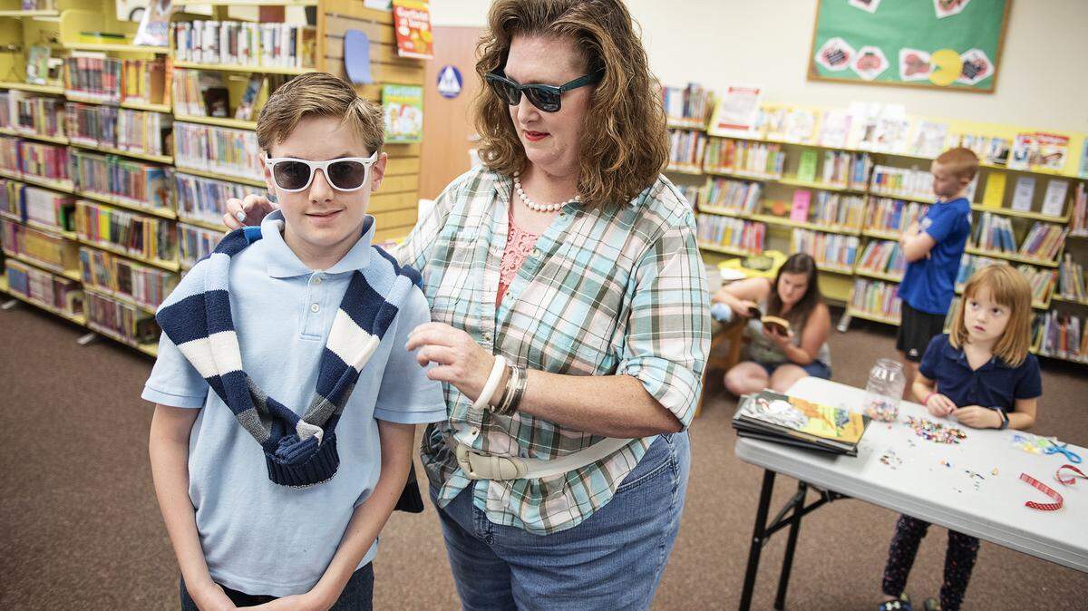 Amy Mowery straightens the eighties style clothing of the her son Sean Mangas,12, during a Õ80s theme party at Stanislaus County Library in Hughson, Calif., Tuesday, July 30, 2019.