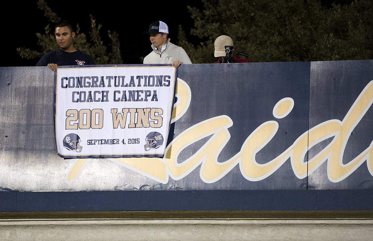 Central Catholic celebrates  coach Roger Canepa after his 200th career victory over Atwater in Modesto, Calif., on Friday, Sept. 4, 2015. Central Catholic won the game 49-0.