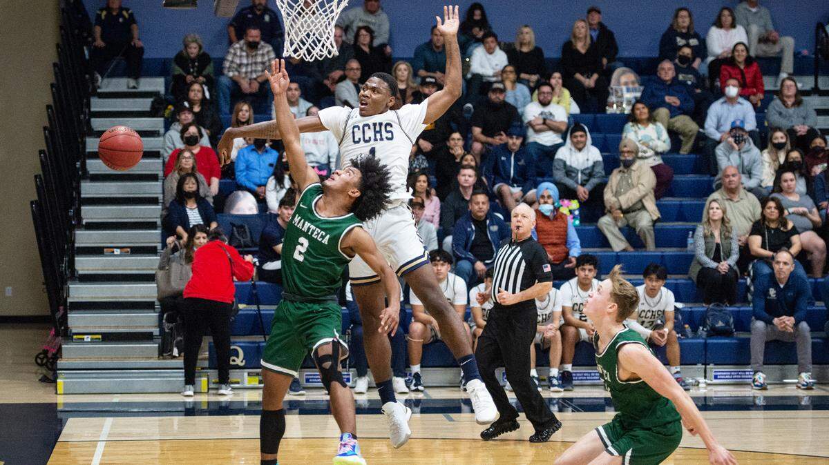 Central Catholic’s Malachi Miller blocks the layup of Manteca’s Trey Moreland during a Valley Oak League game at Central Catholic High School in Modesto, Calif., on Wednesday, Feb. 9, 2022. Manteca won the game 39-33.
