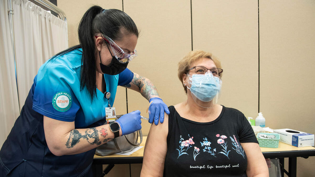 Sutter Health medical assistant Wendy Rogers, left, gives Maria Marcelino a COVID-19 vaccine during an appointment only clinic for its members in Modesto, Calif., on Wednesday, Feb. 10, 2021.