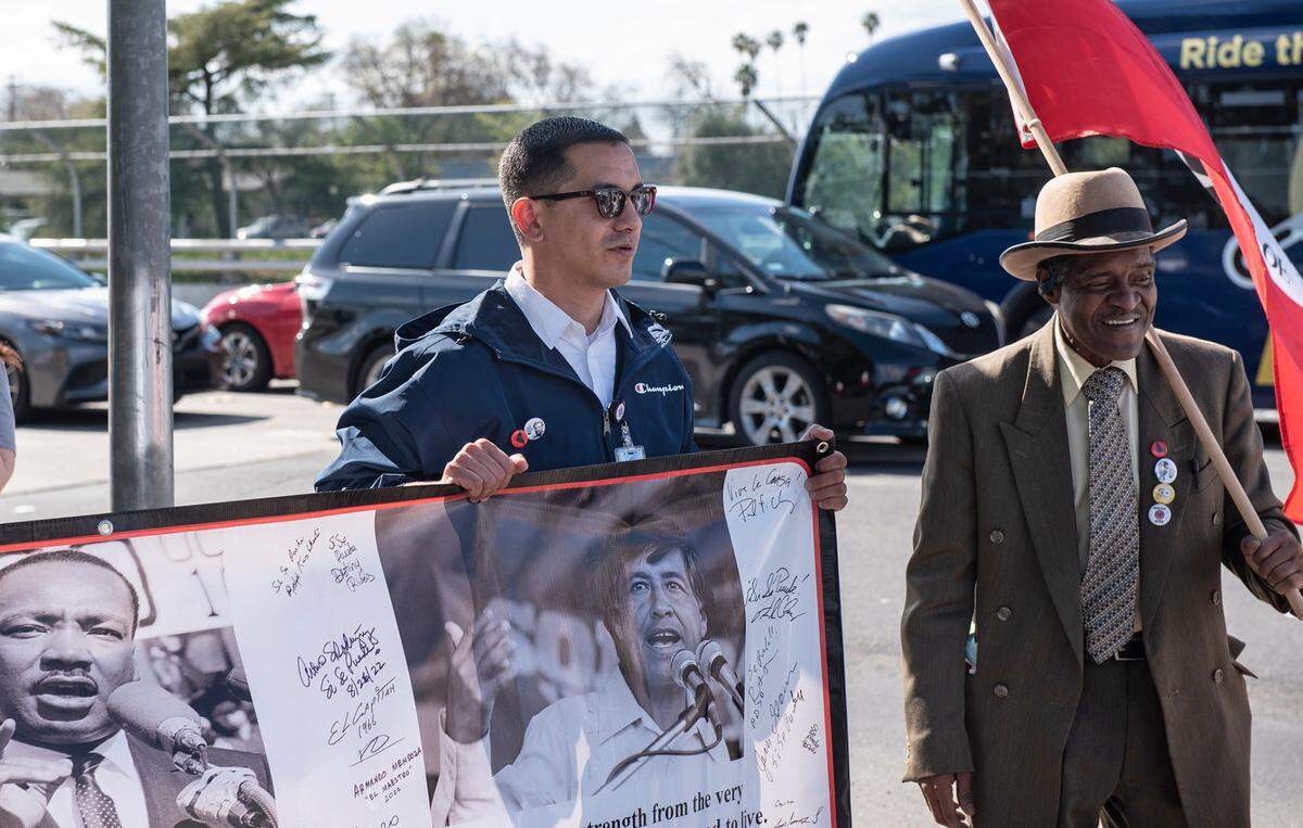 Modesto council member Eric Alvarez, left, Sebastian Jones and others marched from Chavez Park to 10th Street plaza to commemorate the birthday of labor leader Cesar Chavez in Modesto, Calif., Friday, March 31, 2023.