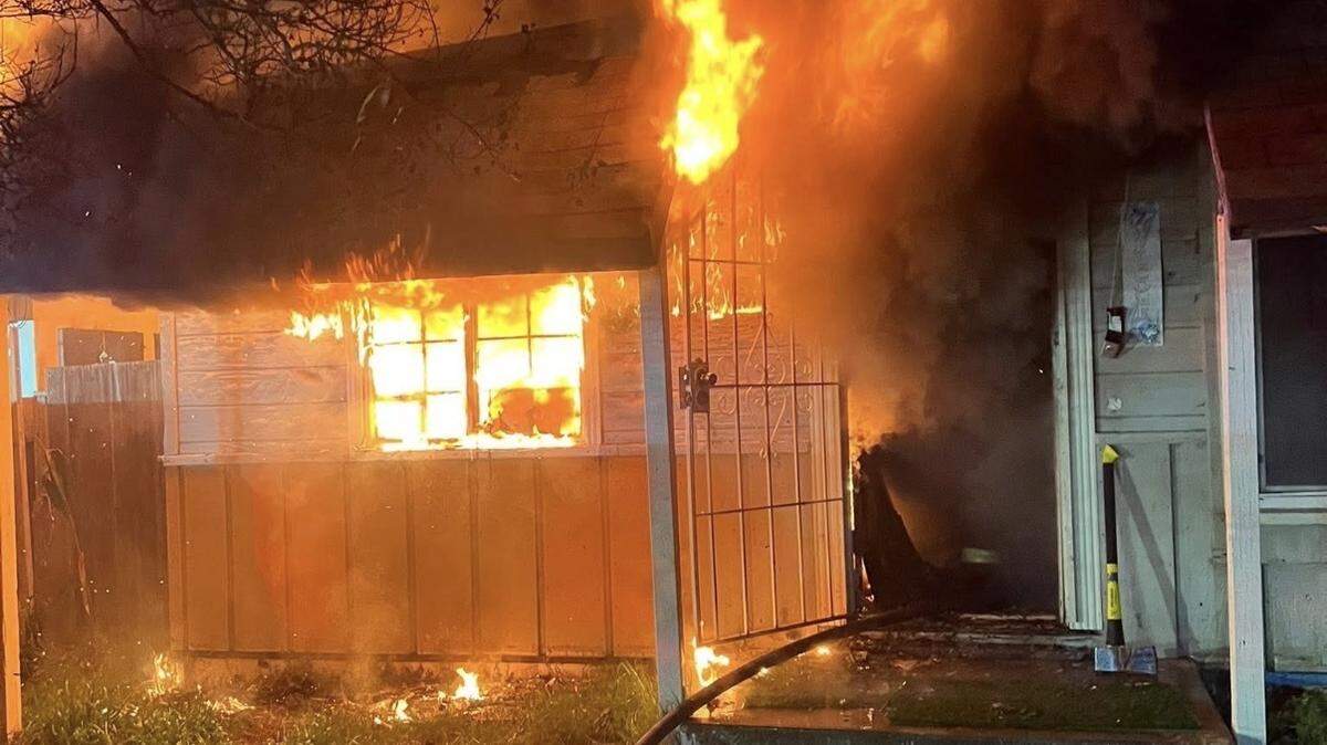 Flames engulf the front of a residence in Turlock early Wednesday morning after investigators said the homeowner intentionally set the fire. The blaze damaged two structures on the property.