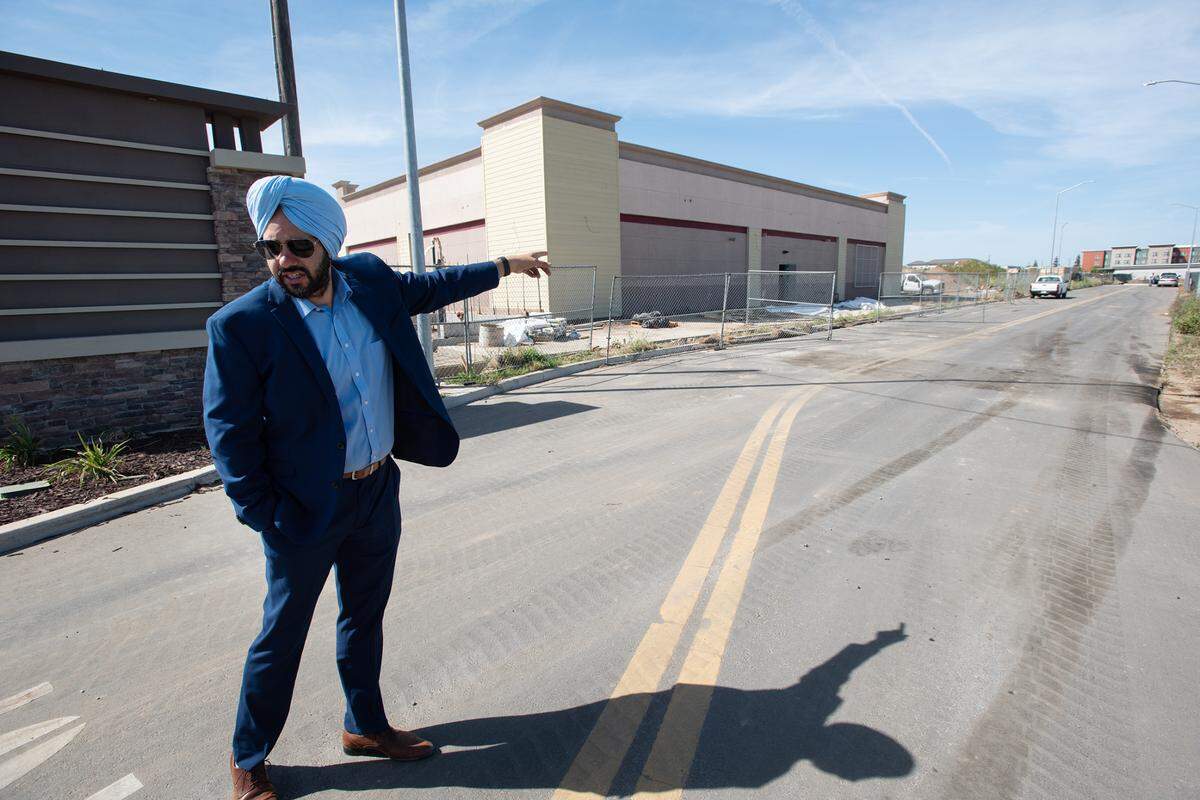 Developer Mani Grewal points to the site where ground preparation for a new hotel has started on Dale Road in Modesto, Calif., on Thursday, March 24, 2022.
