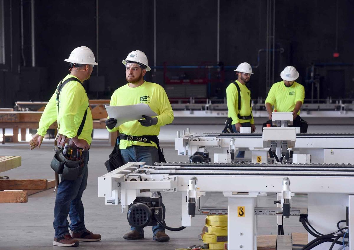 Entekra employees Alejandro Jimenez (2nd from left) and Rodolfo Varelas work on plans for internal walls on Monday November 4, 2019 at Entekra in Modesto, Calif.