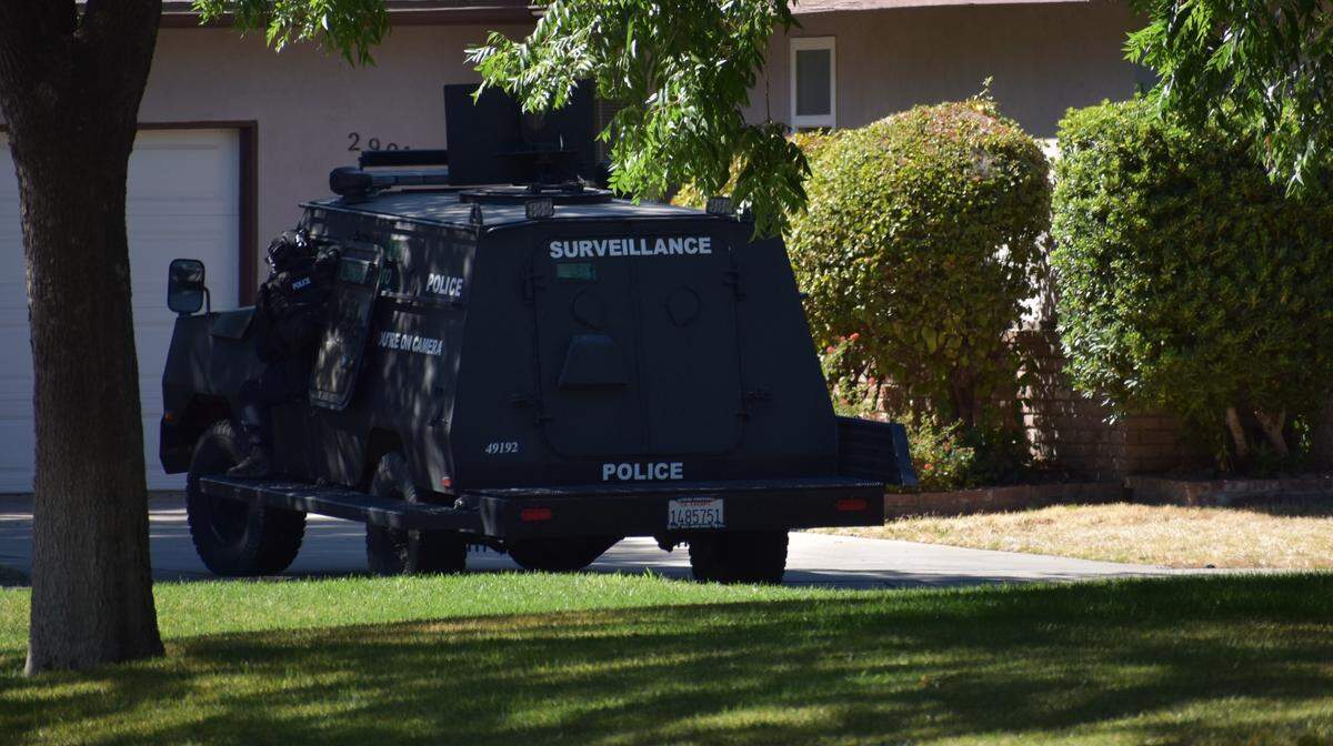 A police officer parks a surveillance vehicle in the driveway of a home following a fatal shooting on Debbie Lane in central Modesto on Sunday afternoon, July 10, 2022.