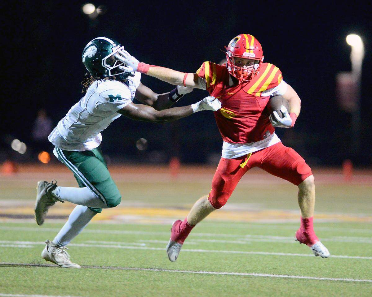 Oakdale running back Chase Lopez (6) stiff arms a defender during the game with Manteca at Oakdale High School in Oakdale, Oct. 31, 2025.