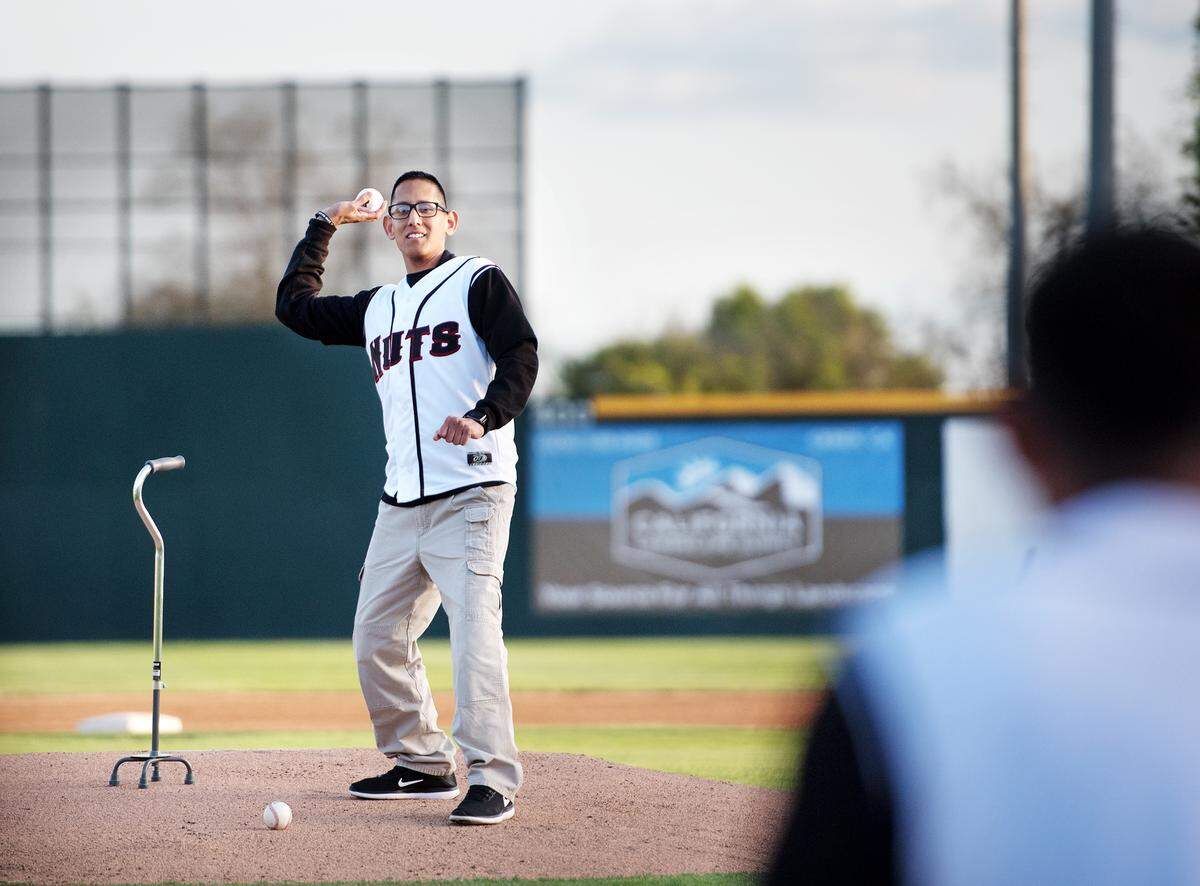 Modesto Police officer Juan Arroyo throws out the first pitch at during the Modesto Nuts home opening game at John Thurman Field in Modesto, Calif., on Thursday, April 12, 2018. Arroyo was critically injured by a suspected drunk driver while on duty in January.